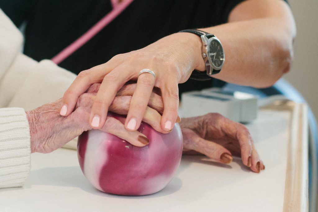A nurse helps assist a long term care, short term care patient in physical therapy