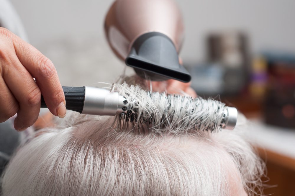 A woman gets her hair styled by a salon at a skilled nursing facility nursing home
