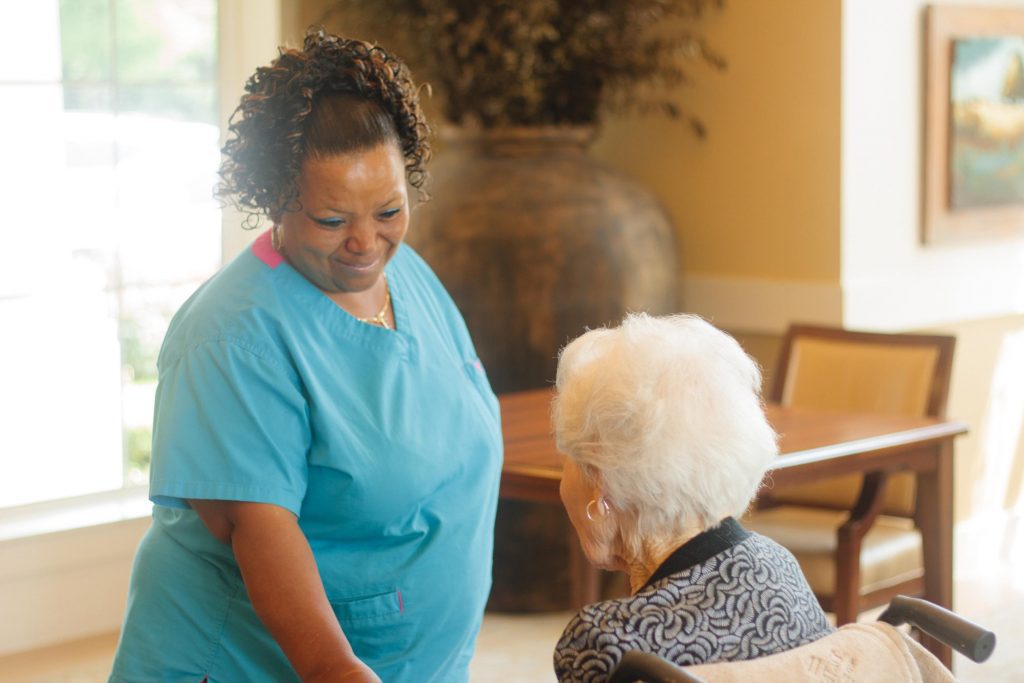 A nurse smiles at a respite care patient at a skilled nursing facility