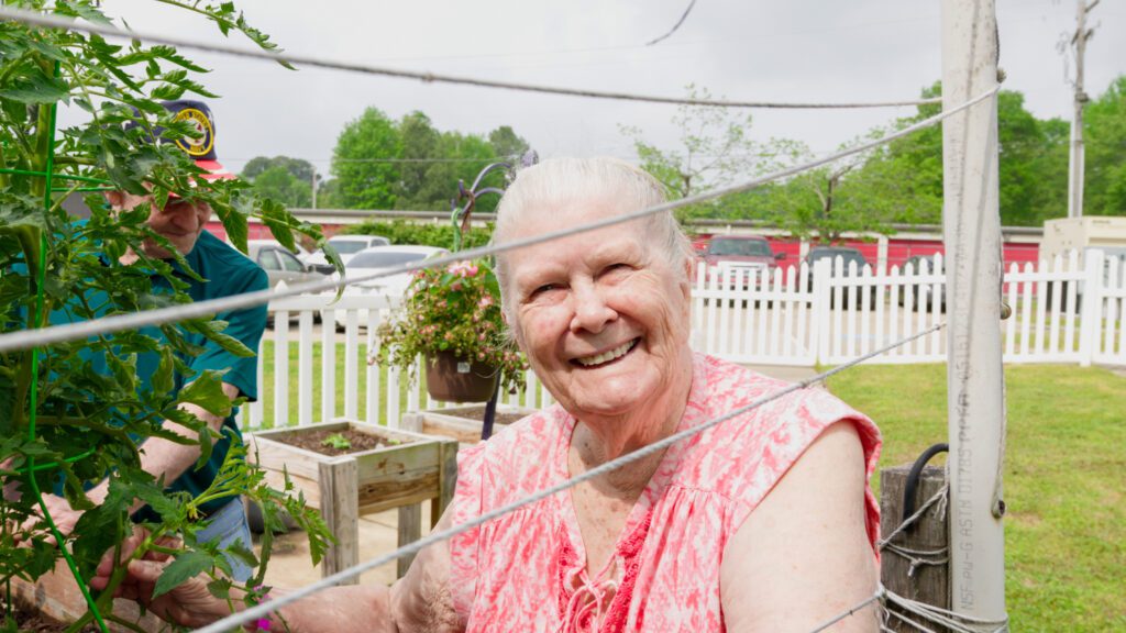 A woman in a shared garden at a skilled nursing nursing home